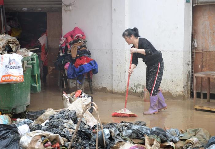 4月21日,洪水事后,广东省韶关市武江区龙归镇的住户在算帐路面。新华社记者 卢汉欣 摄